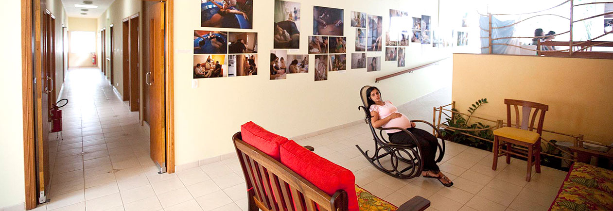 Foto de uma mulher grávida descansando em uma cadeira de balanço na Casa Angela.